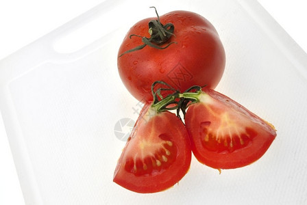用白色背景孤立的红番茄切割白色塑料板图片