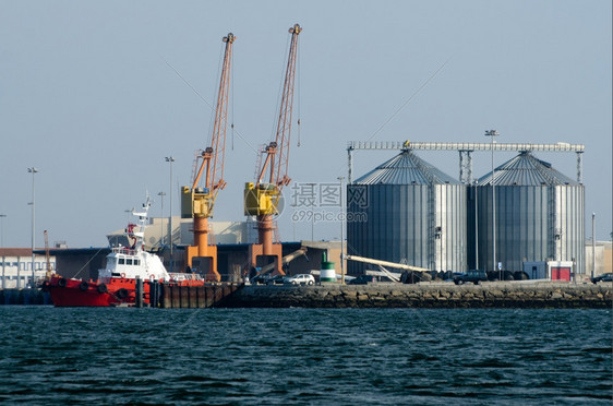与起重机和红色拖船进行海港贸易的观察图片