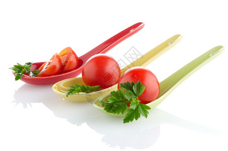 新鲜西红柿和鹦鹉叶在陶瓷勺图片