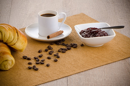 杯黑咖啡和羊角面包的图片