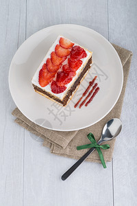 巧克力草莓蛋糕在白板和木桌上图片