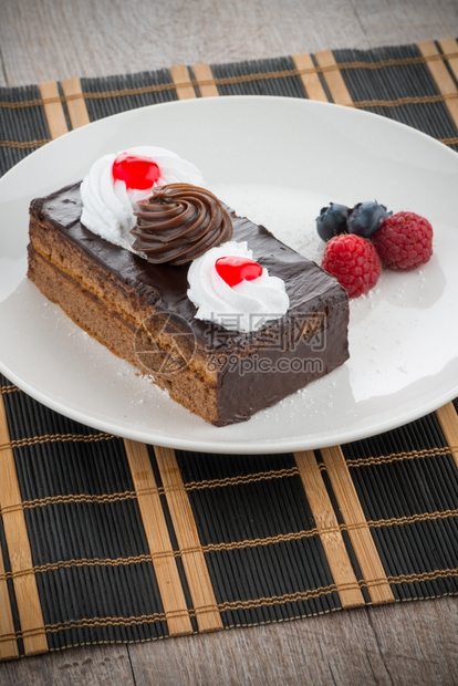 一块巧克力蛋糕白盘上有浆果图片