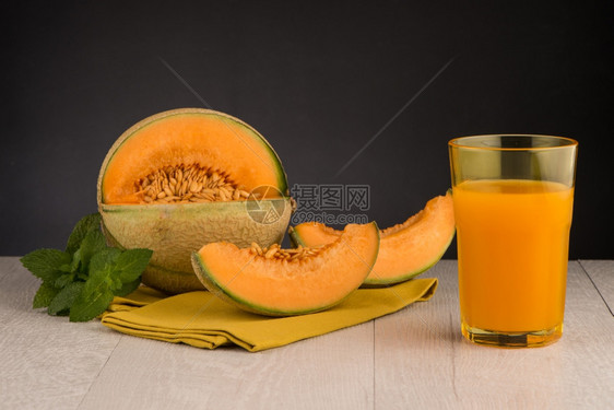 木桌背景上的蜜瓜汁图片