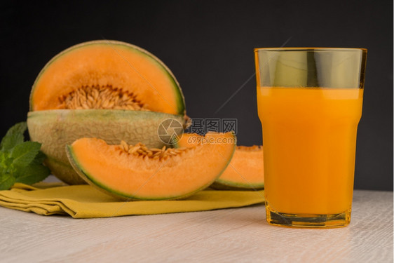 木桌背景上的蜜瓜汁图片