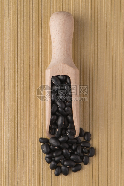 用黑色豆子和黄乙烯基底的木制勺子图片