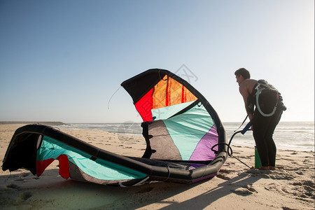 Kitesurfer在海滩美丽的日落上准备了设图片