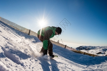 山上坐着滑雪车的骑士面对蓝天的阳光照耀图片