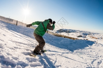 山上坐着滑雪车的骑士面对蓝天的阳光照耀图片