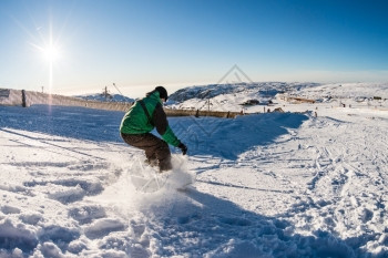 山上坐着滑雪车的骑士面对蓝天的阳光照耀图片