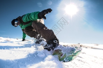 山上坐着滑雪车的骑士面对蓝天的阳光照耀图片