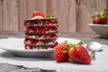 草莓沙漠奶油和面包放在盘子上桌顶端图片