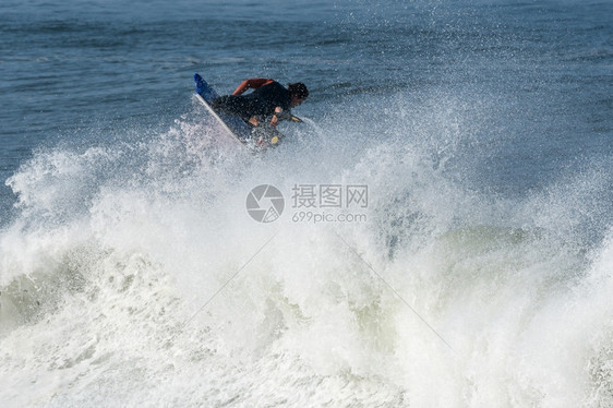 在阳光明媚的一天在海浪上行驶图片