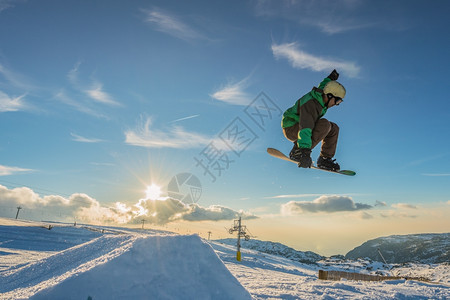 滑雪运动员对日落的天空进行彻底的跳跃图片