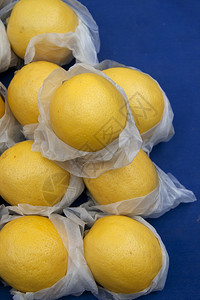 在公开市场柜台的蓝色背景的新鲜柠檬图片