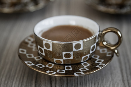 美味的土耳其传统咖啡在木制背景不同的金咖啡杯中供应图片