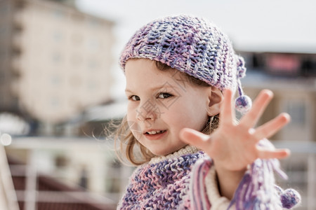 紫贝雷帽女孩露出她的手指表示五号图片