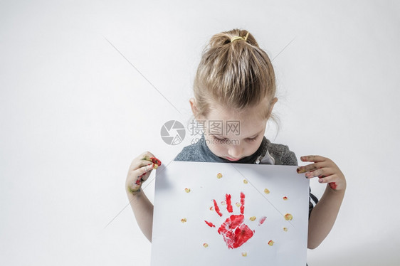可爱的金发女孩用手指涂漆玩和画图片