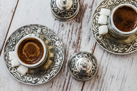 白色木制桌上传统银杯中的土耳其传统咖啡图片
