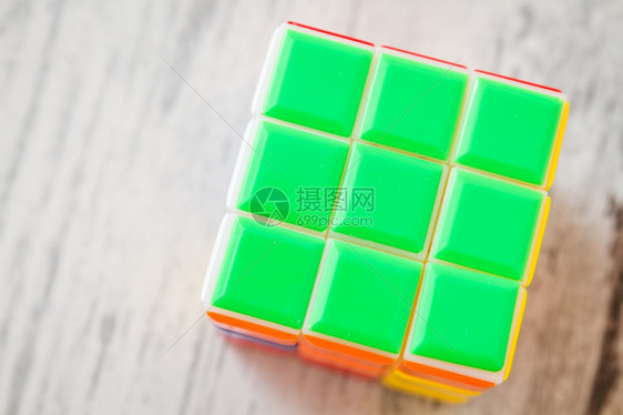 Jigsaw拼图Rubik立方玩具白木背景上的多彩塑料块图片
