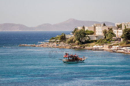 爱琴海土耳其博德鲁姆Akyarlar海滩附近的旅游船背景图片