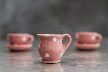 灰底带白点的小粉红色玩具瓷杯和板图片