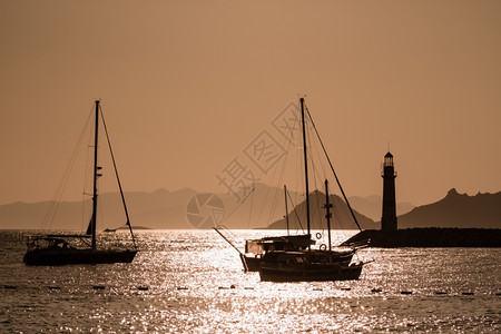 土耳其博德鲁姆日落时的船和灯塔环形轮图片