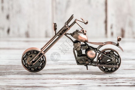 白色木背景的可爱小型金属摩托车图片