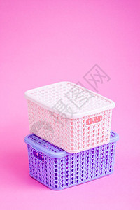 粉红色背景的多彩微型塑料篮图片