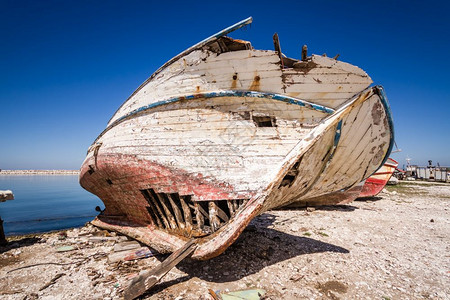 遗弃在岸边的旧渔船图片