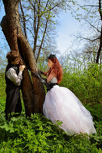 一对夫妇站在树旁看着对方户外拍摄图片