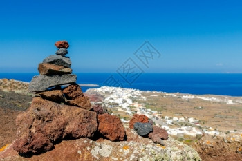 圣托里尼岛奥亚村背景的一座小火山岩石金字塔图片