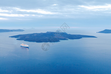 Fira日落时海湾和Kolder的景象海湾上有灯光的客轮圣托里尼希腊图片