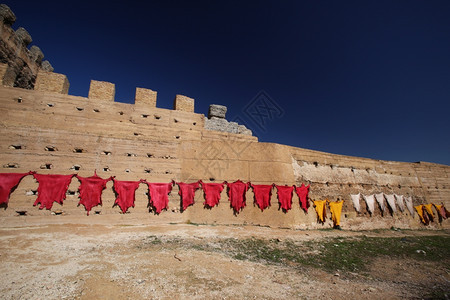 在北部非洲摩洛哥历史悠久的Fes镇旧城墙前皮革生产在附近的太阳上新鲜皮革干燥图片