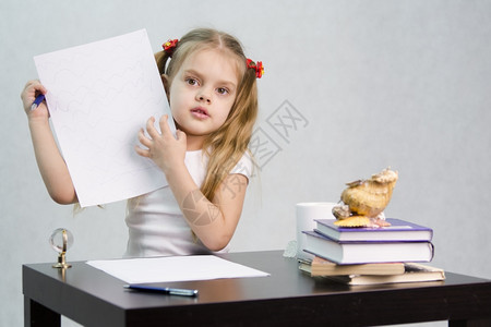 女孩坐在桌子上一张纸Doodle上写作有书籍纸笔玻璃球的有茶杯海壳图片