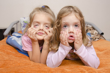 两个女孩拉了一张可怕的脸躺在沙发上图片