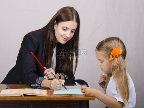 老师正在教学生写作业图片