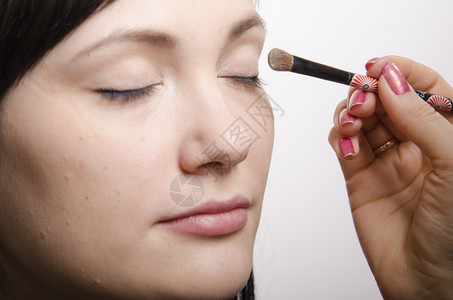 化妆师在模型Q39上做化妆品脸她画上层眼皮模型的阴影图片