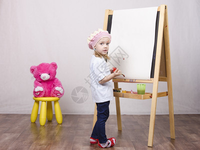 三岁女孩在艺术家中玩耍女孩在坐椅子上着的熊画壁图片
