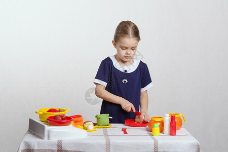 女孩在桌子上玩厨房玩具图片