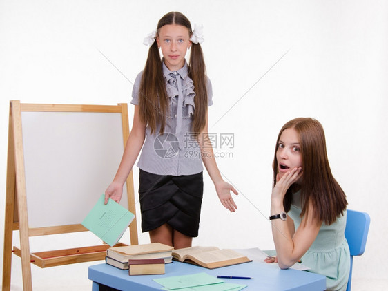 学生站在黑板上老师坐在书桌旁听学生讲话图片