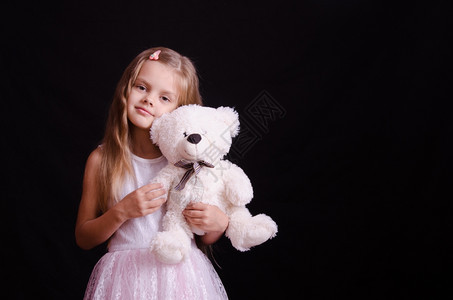 一个美丽的女孩拿着泰迪熊摆姿势拍照图片