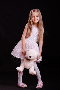 一个美丽的女孩拿着泰迪熊摆姿势拍照图片