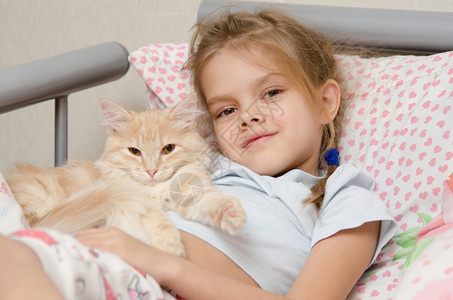 女孩和一只小猫躺在床上图片