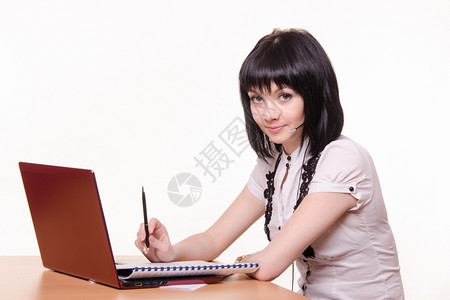 坐在呼叫中心的桌子上穿着白色衣的笔记本电脑可爱小女孩图片