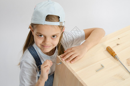小女孩收藏家具的用斧扳手围在木板架箱上图片