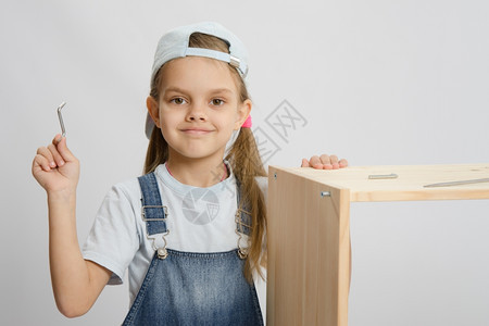 小女孩收集家具和木制壁架箱周围的斧扳手图片