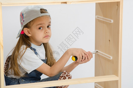 女孩手持螺丝起子的家具收藏手持螺丝起子的家具收藏木制柜子女孩手持螺丝起子的家具收藏图片