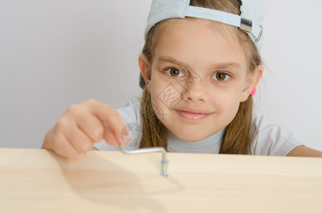 6岁女孩玩耍和收集木柜子女孩用艾伦的钥匙扭转螺丝图片