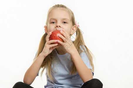 6岁女孩坐着吃苹果6岁女孩坐着欧洲人拿苹果吃图片