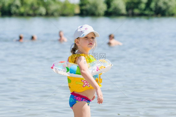 女孩穿着游泳圈着海边游泳图片